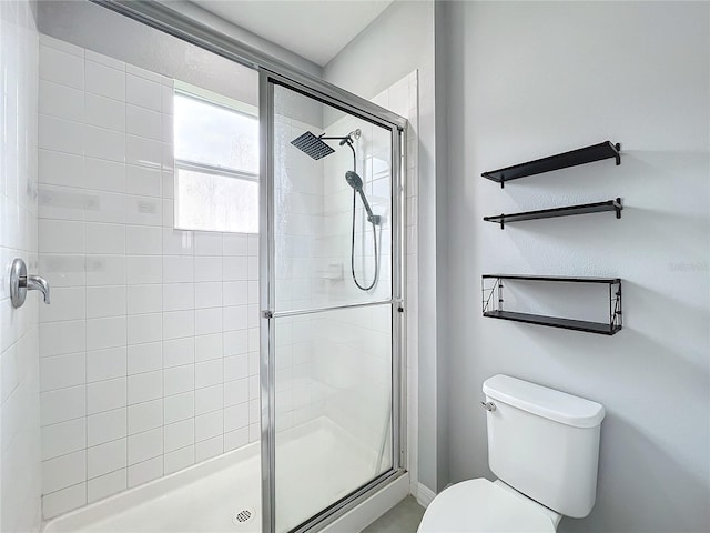 bathroom featuring a stall shower and toilet