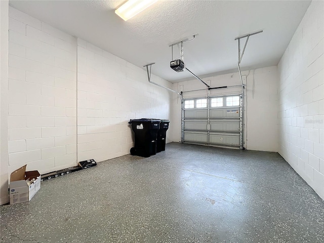 garage with concrete block wall and a garage door opener