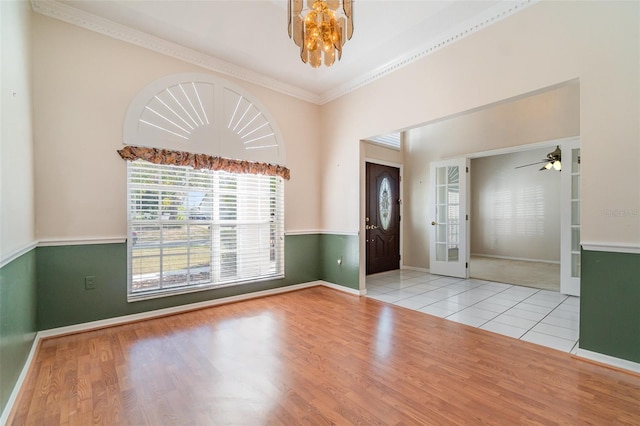 entryway with ceiling fan with notable chandelier, ornamental molding, and light hardwood / wood-style floors