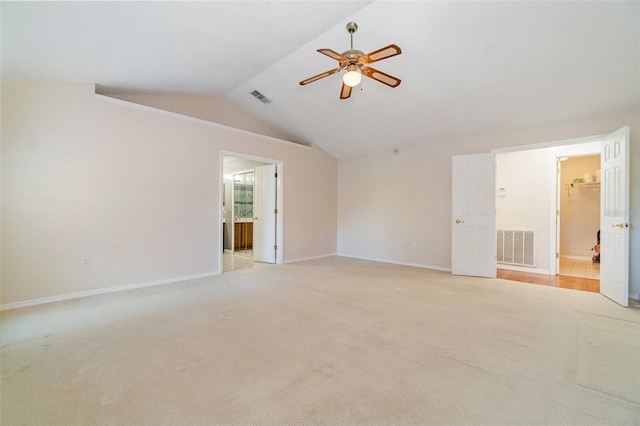 spare room featuring light colored carpet, ceiling fan, and vaulted ceiling