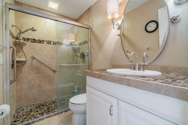 bathroom with tile patterned floors, vanity, toilet, and an enclosed shower