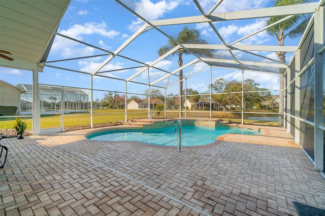 view of pool with a lanai, a lawn, and a patio