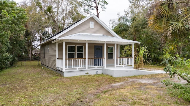 bungalow featuring covered porch and a front lawn