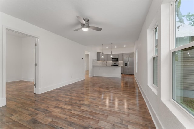 unfurnished living room with ceiling fan and dark hardwood / wood-style flooring