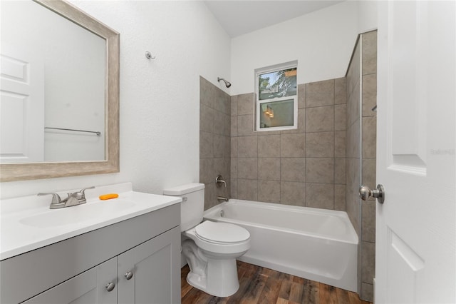 full bathroom featuring hardwood / wood-style flooring, vanity, toilet, and tiled shower / bath combo