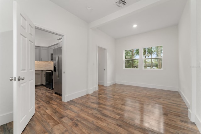 unfurnished room featuring dark hardwood / wood-style floors and beamed ceiling