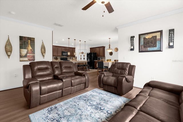 living room featuring crown molding, ceiling fan, and dark hardwood / wood-style flooring