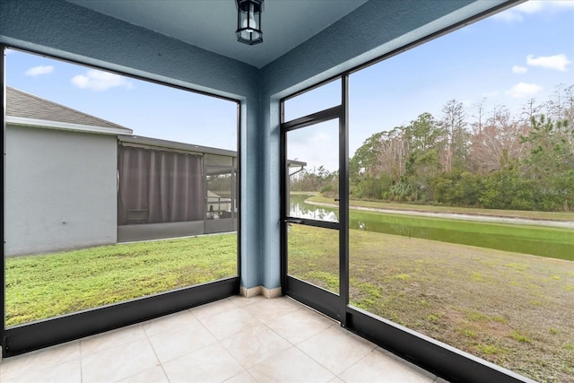 unfurnished sunroom featuring a water view