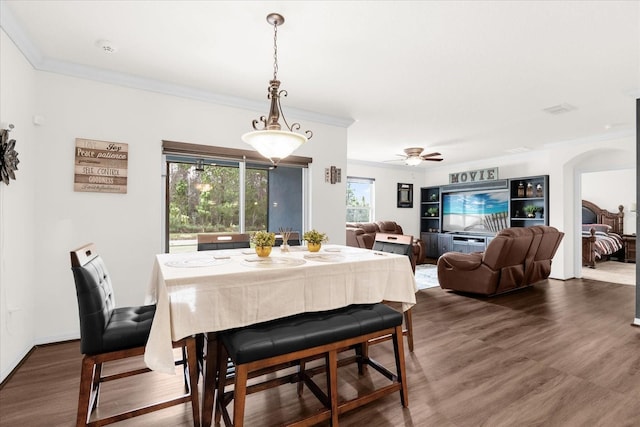 dining space featuring ceiling fan, ornamental molding, and wood-type flooring