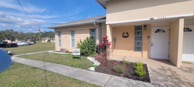 property entrance with a lawn