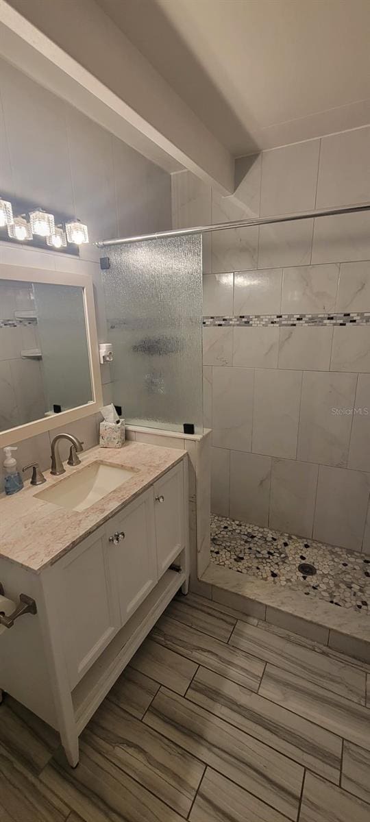 bathroom with vanity and tiled shower