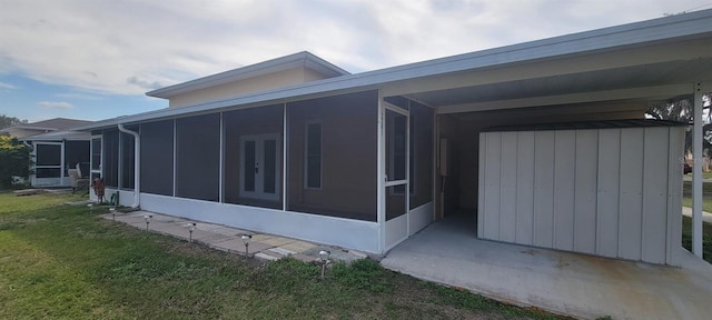 view of home's exterior featuring a sunroom and a yard