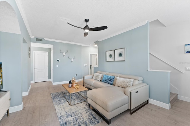 living room with crown molding, light hardwood / wood-style floors, ceiling fan, and a textured ceiling