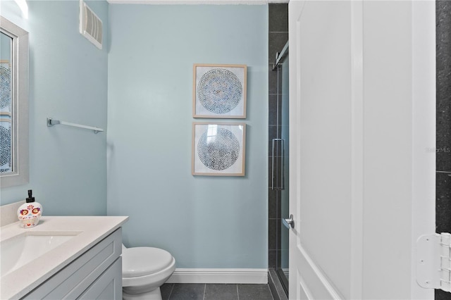 bathroom with vanity, toilet, a shower with shower door, and tile patterned flooring