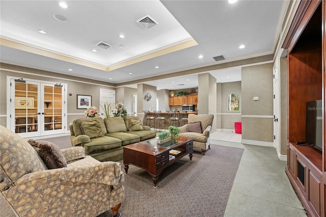 carpeted living room featuring french doors, a tray ceiling, and crown molding