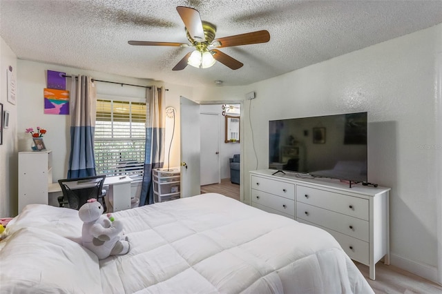 bedroom featuring ceiling fan, a textured ceiling, and light hardwood / wood-style flooring