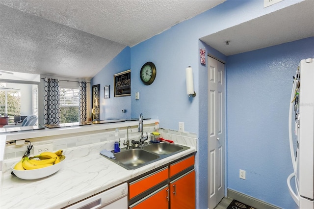 kitchen featuring lofted ceiling, sink, a textured ceiling, white appliances, and decorative backsplash