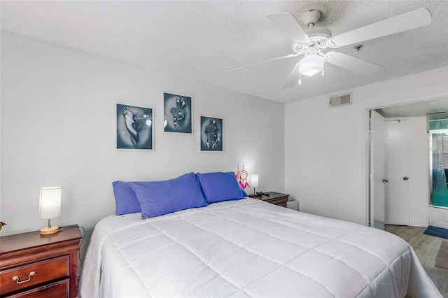 bedroom with hardwood / wood-style floors, a textured ceiling, and ceiling fan