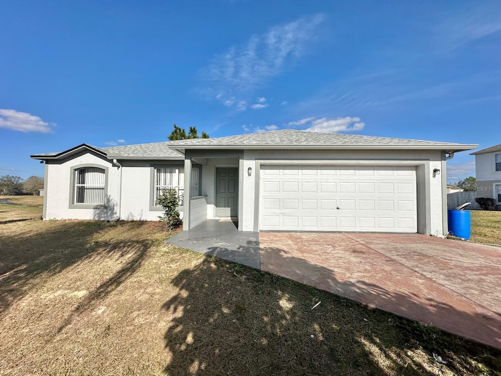 ranch-style home with a garage and a front lawn