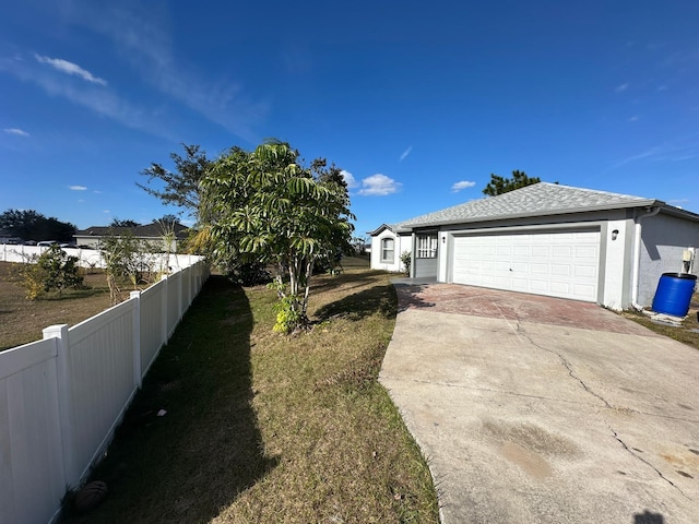 view of side of home featuring a garage and a lawn