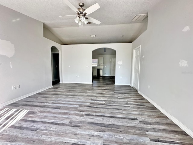 unfurnished living room featuring hardwood / wood-style flooring, lofted ceiling, a textured ceiling, and ceiling fan