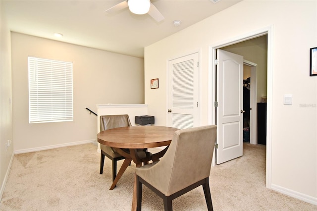 dining space with light colored carpet and ceiling fan