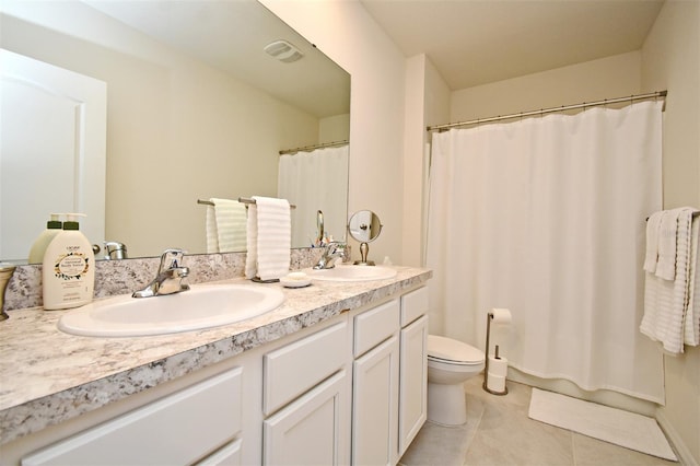 bathroom with tile patterned flooring, vanity, toilet, and walk in shower