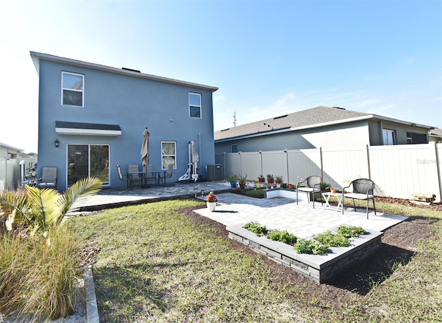 back of house featuring a lawn and a patio