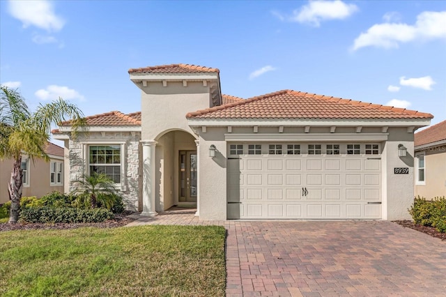 mediterranean / spanish-style house with a garage and a front yard