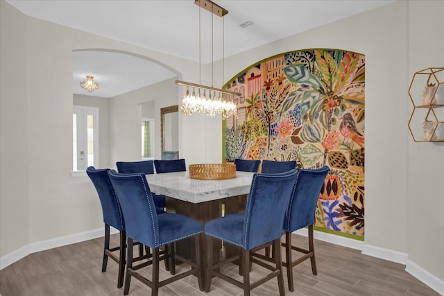 dining space featuring dark hardwood / wood-style flooring and a chandelier