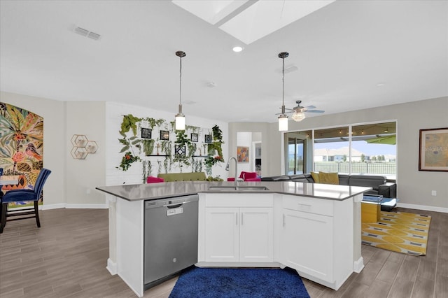 kitchen with sink, a skylight, hanging light fixtures, dishwasher, and white cabinets