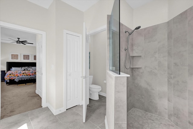 bathroom featuring tile patterned flooring, a tile shower, ceiling fan, and toilet