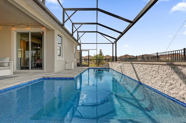 view of pool with a patio area and glass enclosure