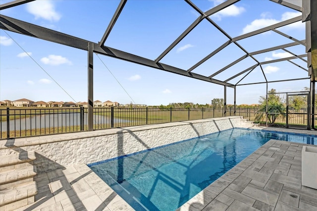 view of swimming pool featuring a water view, a patio area, and glass enclosure