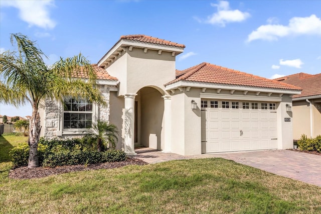 mediterranean / spanish-style house with a garage and a front lawn