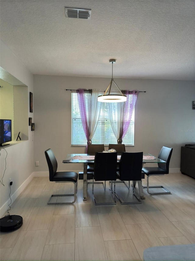 dining space featuring a textured ceiling