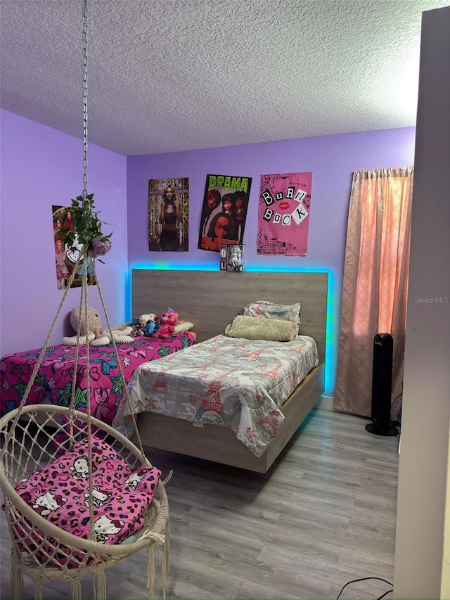 bedroom with hardwood / wood-style floors and a textured ceiling