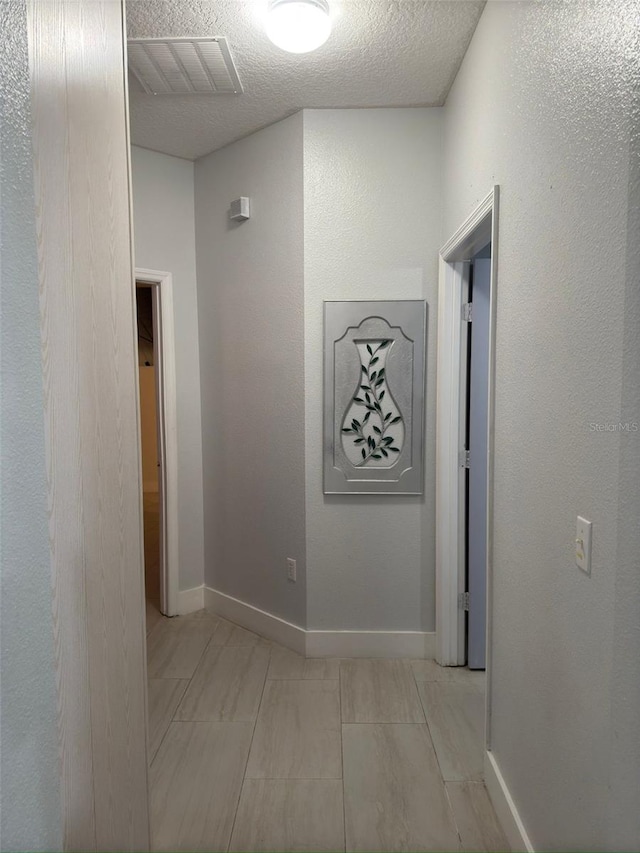 hallway with a textured ceiling