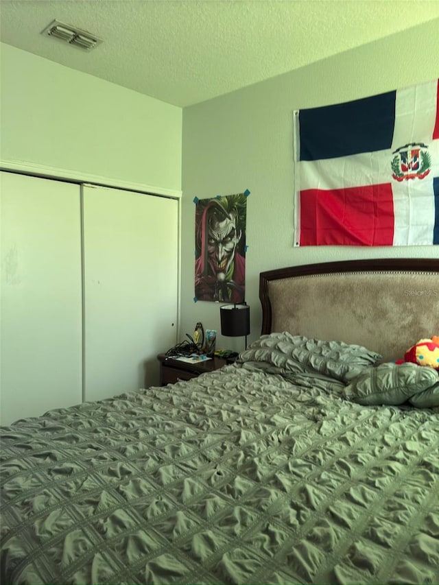 bedroom featuring a textured ceiling and a closet