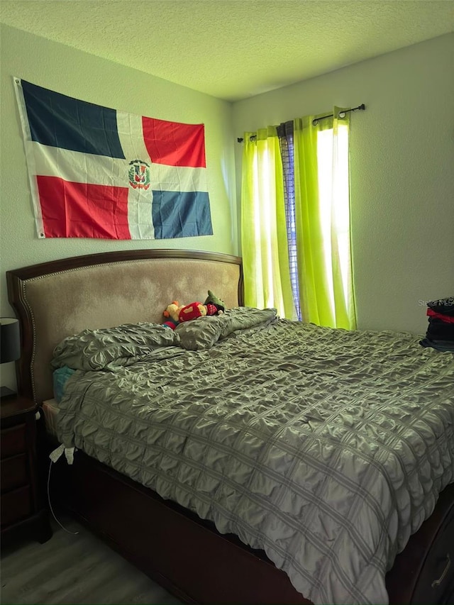 bedroom featuring hardwood / wood-style flooring and a textured ceiling