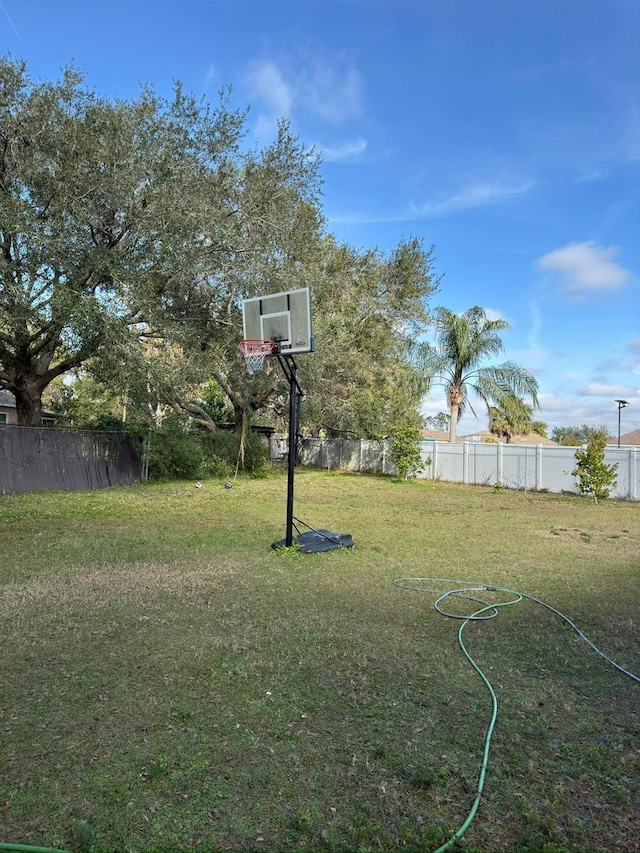 view of sport court featuring a yard