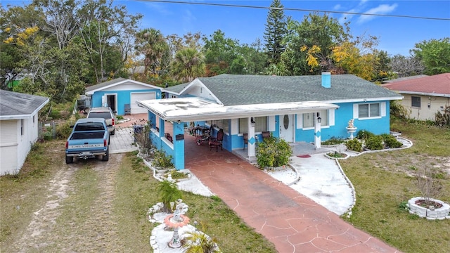 view of front of property with an outbuilding, a garage, covered porch, and a front yard