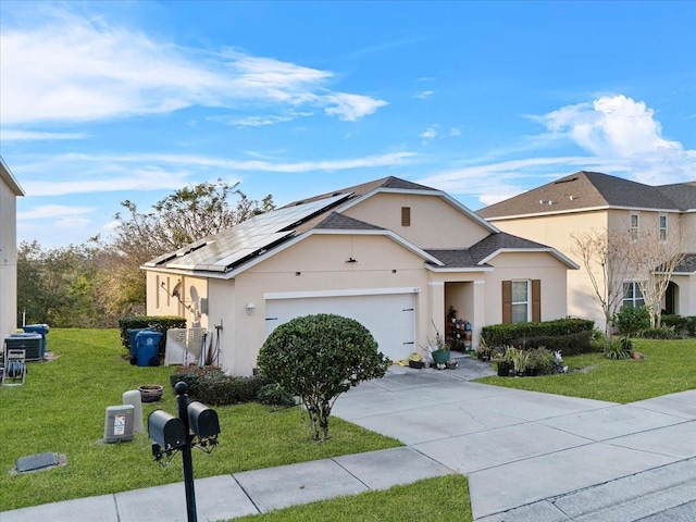 view of front of home featuring stucco siding, solar panels, a front yard, a garage, and driveway