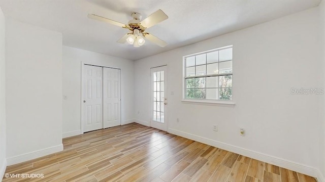 unfurnished bedroom with ceiling fan, light wood-type flooring, and a closet