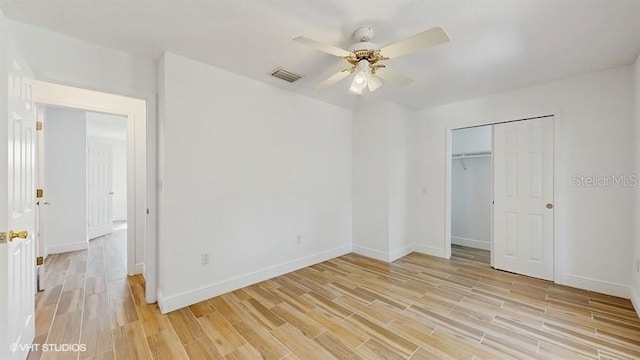 unfurnished bedroom featuring light hardwood / wood-style floors, a closet, and ceiling fan