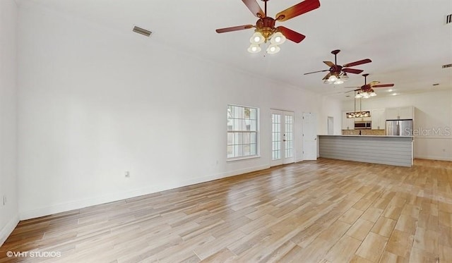 unfurnished living room featuring french doors and light wood-type flooring