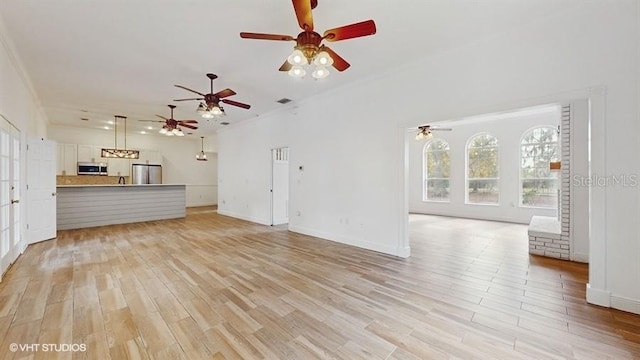 unfurnished living room with crown molding and light hardwood / wood-style floors