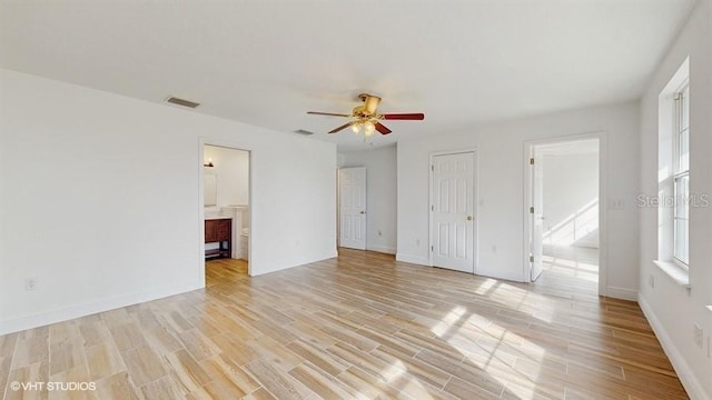 empty room featuring ceiling fan, plenty of natural light, and light hardwood / wood-style flooring