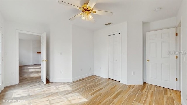 unfurnished bedroom with ceiling fan, light hardwood / wood-style floors, and a closet