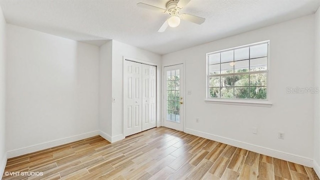 unfurnished bedroom featuring ceiling fan, light hardwood / wood-style flooring, and a textured ceiling